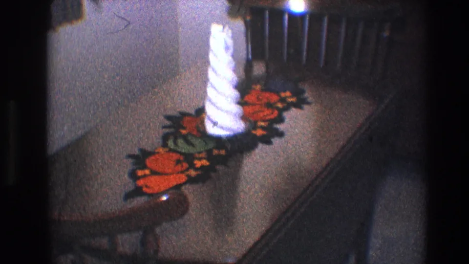 1968 Toledo frame with a white twisted candle on an orange-and-green crocheted table runner in a private home interior.