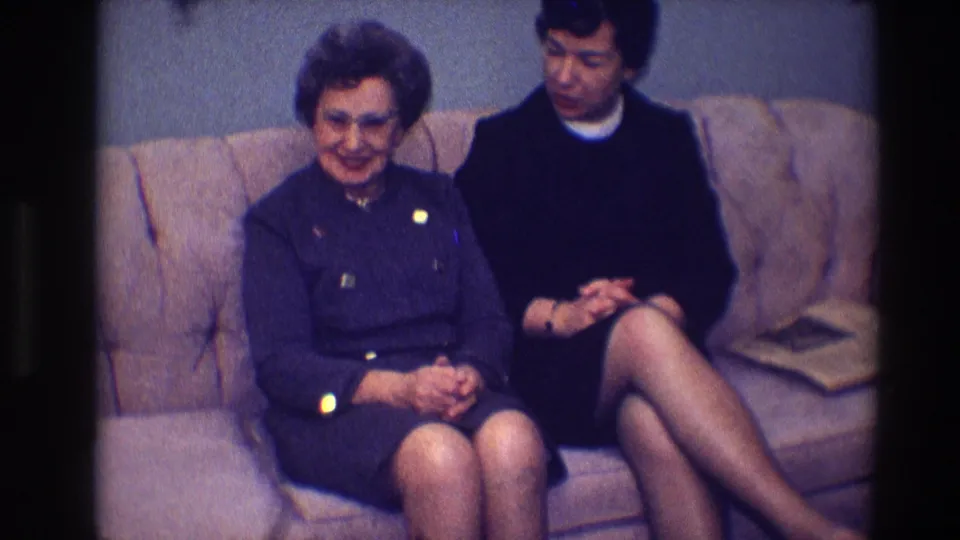 The final 1968 Toledo frame shows two women seated on the tan sofa as the older woman smiles toward the room.