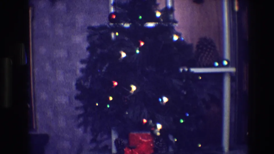 1968 Toledo home-movie frame of a decorated Christmas tree with multicolored bulbs, pinecones, and visible 8mm frame edges.