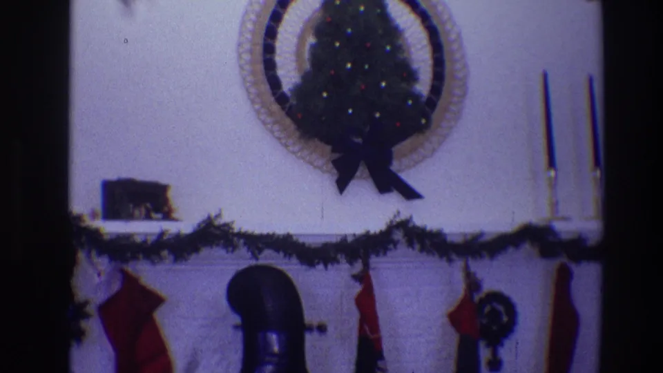 1968 Toledo living-room view with a small decorated Christmas tree, wall wreath, fireplace mantel garland, stockings and tall candlesticks.