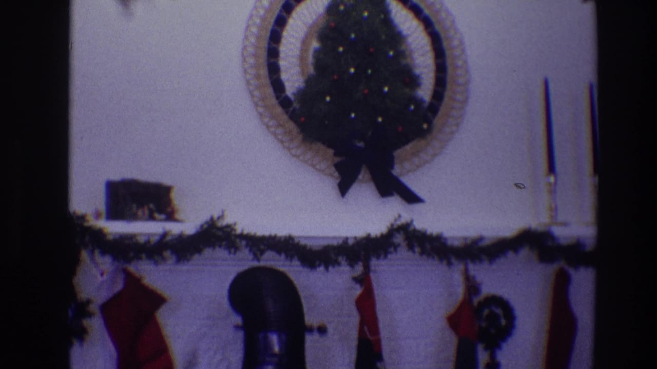Mantel decorations with circular tree display, garland, stockings, candles, and dark pipe.