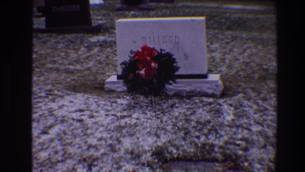 1968 Toledo cemetery frame showing a white Willard grave marker with an evergreen wreath and red bow at its base.