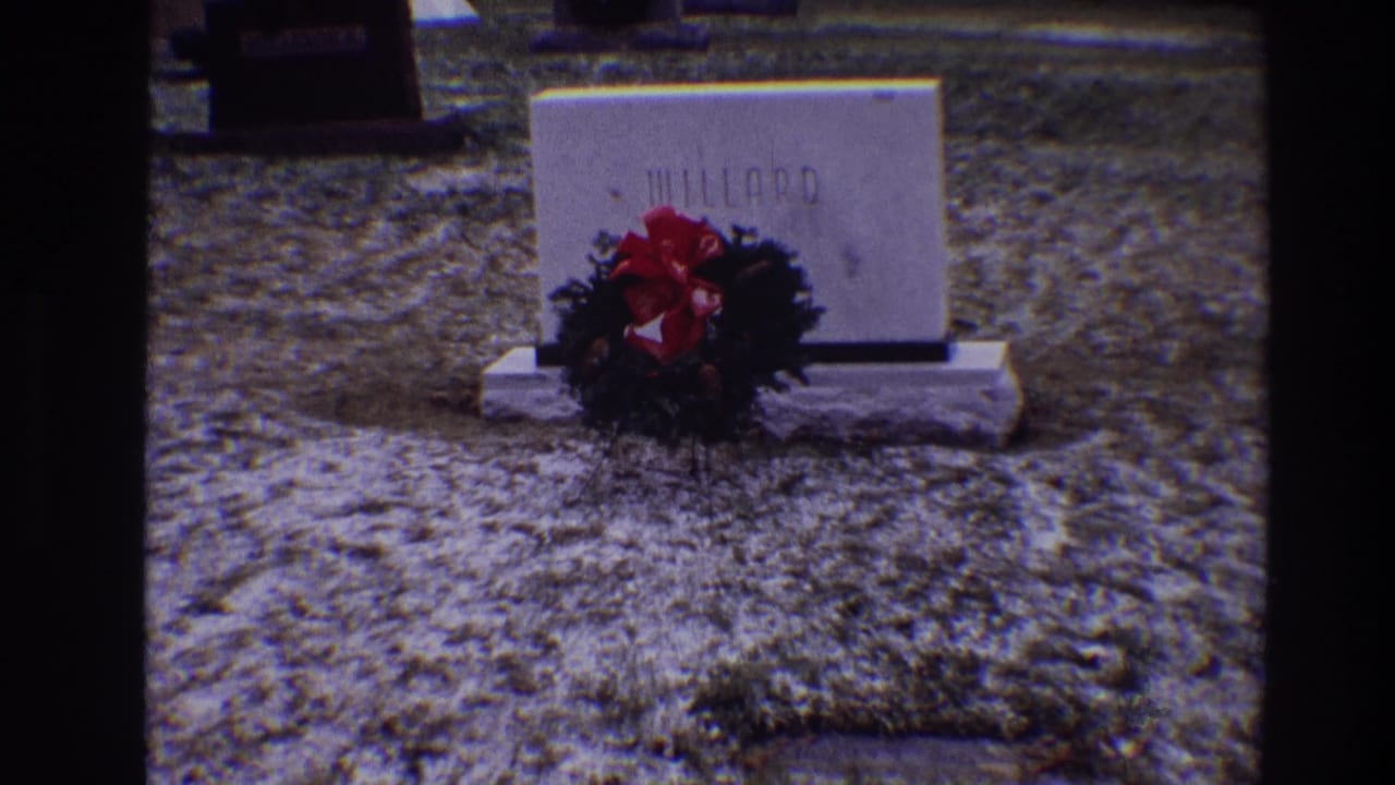 Willard gravestone and red wreath seen from a similar cemetery angle.