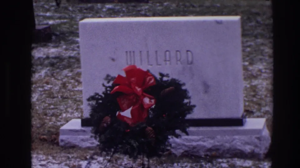 1968 Toledo 8mm frame with a close view of the WILLARD grave marker, evergreen wreath, red bow, and winter ground.