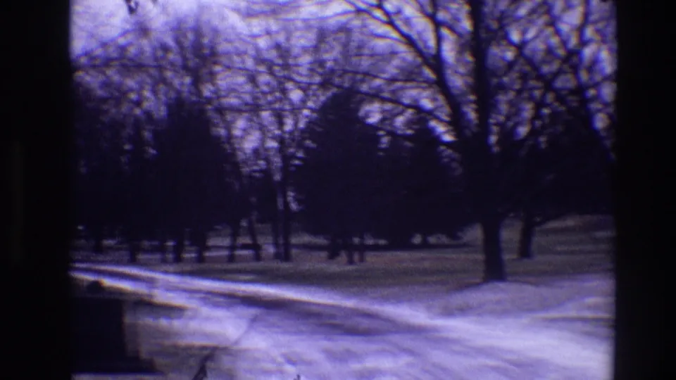 Late clip frame shows the icy Toledo cemetery road continuing past bare trees, low markers, and snow-dusted grass.