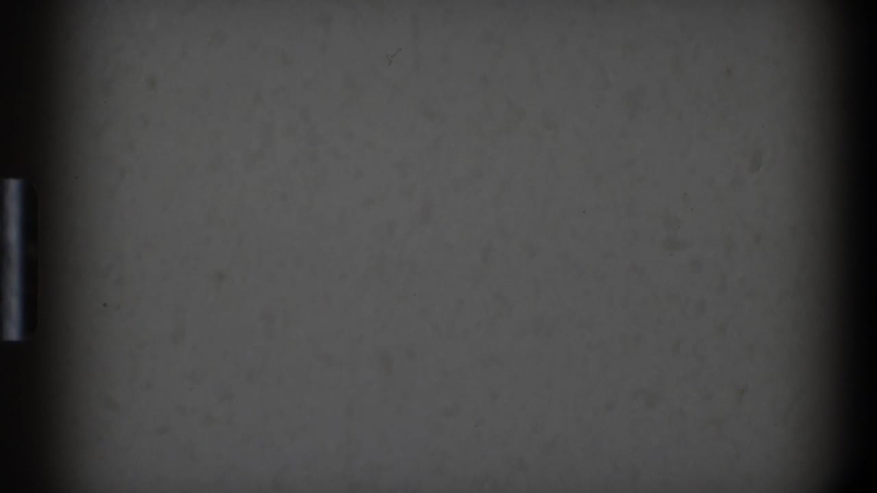 Gray textured surface with dark film edges and a small vertical bright mark.