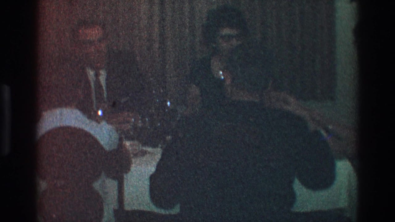 Adults seated at a dim dinner table with a white tablecloth and dark curtains behind them.