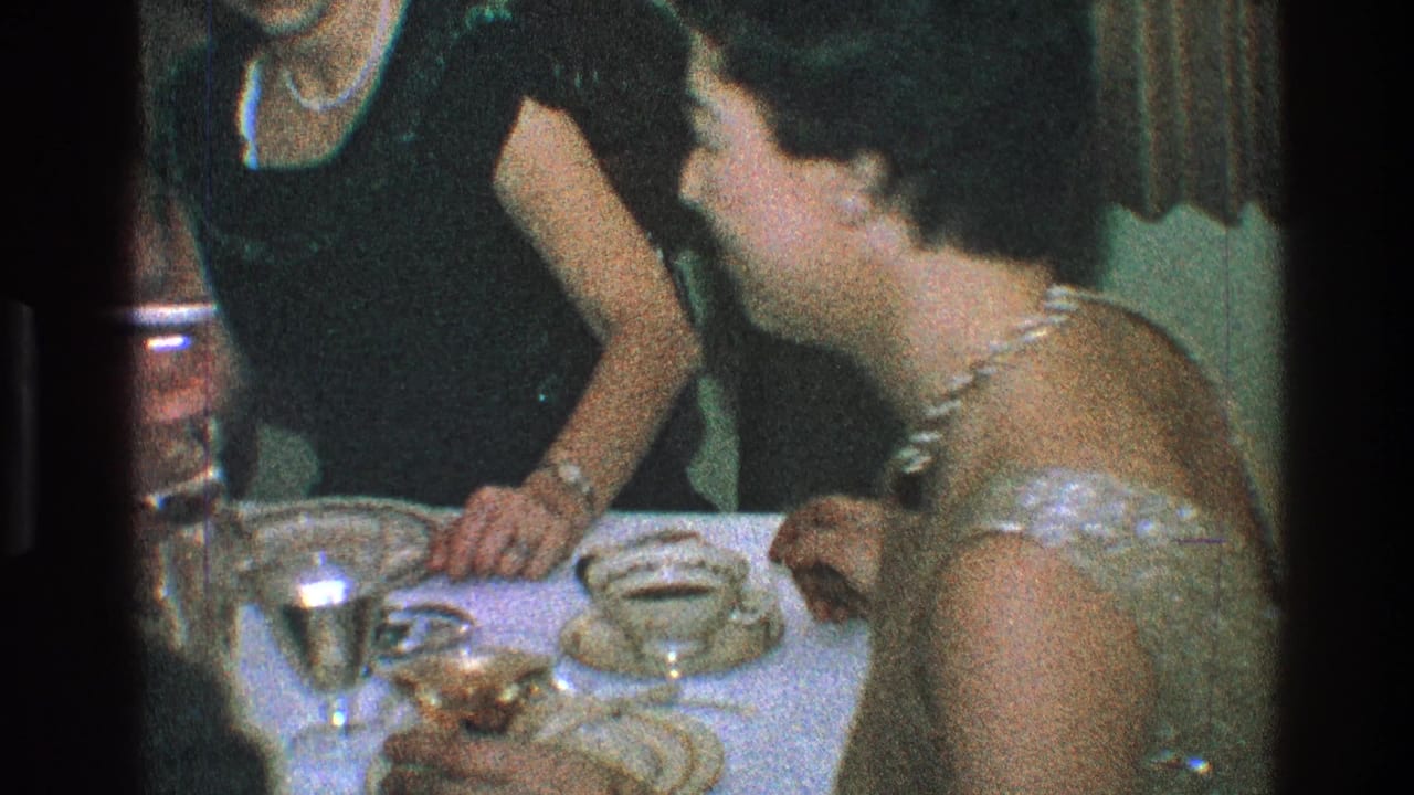 Adults in formal attire seated at a dinner table with plates and glassware.