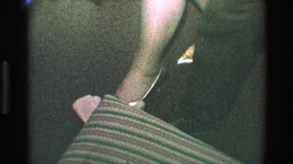 A close 1968 Toledo party frame shows a pointed high-heeled shoe near a crumpled paper or napkin on dark carpet.