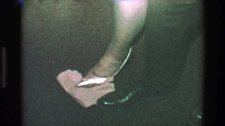 The final party frame shows a pointed heel beside or on a crumpled paper or napkin, filmed close on a dark interior carpet.