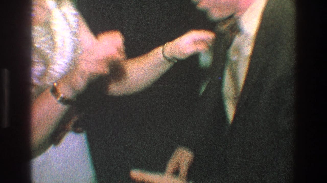 Close view of two adults in dress clothes touching hands during a playful gesture.