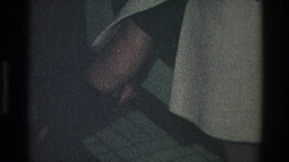 Near the end of the 1968 Toledo clip, the man is low in frame near the woman’s light coat, consistent with helping at her feet.