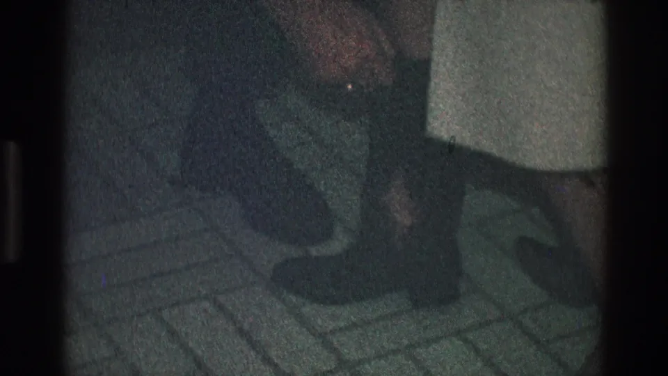 A 1968 Toledo home-movie close-up shows hands near a woman's dark boot, with pale clothing and tile visible.