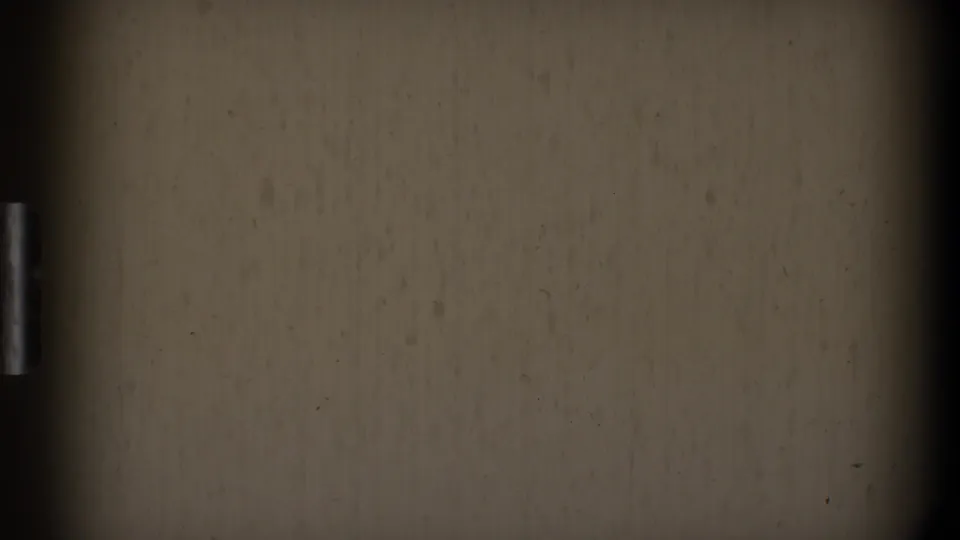 Near-blank 8mm frame showing beige film texture, dark side borders, dust, and age-related surface marks.
