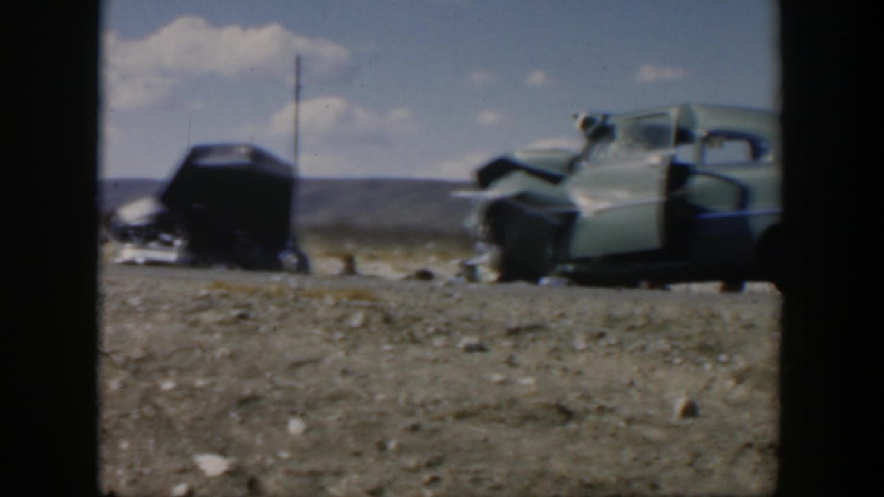 Wide 1951 Texas roadside view of two damaged mid-century cars, with the light green car's door open after a crash.