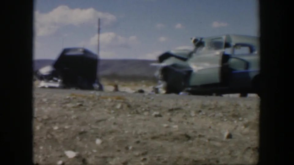 Wide 1951 Texas roadside view of two damaged mid-century cars, with the light green car's door open after a crash.