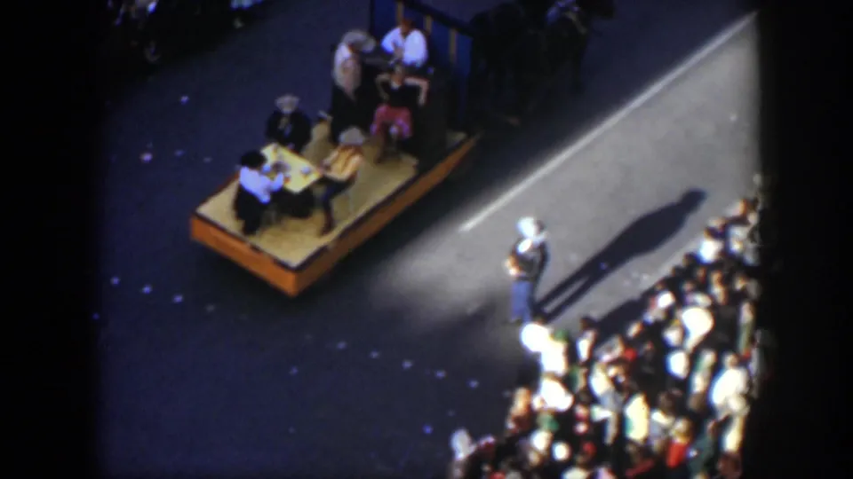 Elevated 1951 Texas parade view with a horse pulling a platform while spectators watch from the curb.