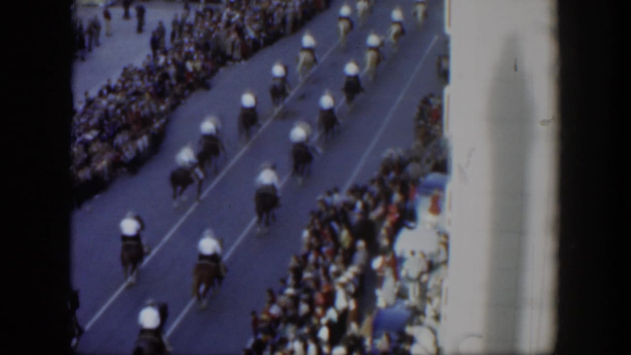 Elevated 1951 Texas parade view with mounted riders in formation and spectators packed along the curb.