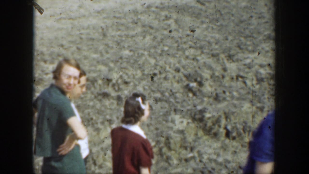 Adults standing near a rough rock wall during an outdoor hike.