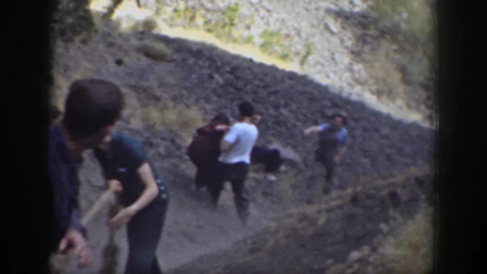Adults on a rugged California hillside appear to respond to a fall during a 1937 8mm home-movie scene.