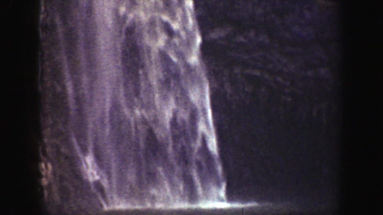1937 California 8mm footage showing waterfall streams falling over rugged rock in a tightly framed home-movie view.