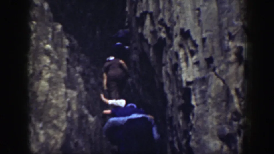 Two men in hats climb a steep rock face in California 1937 home-movie footage.
