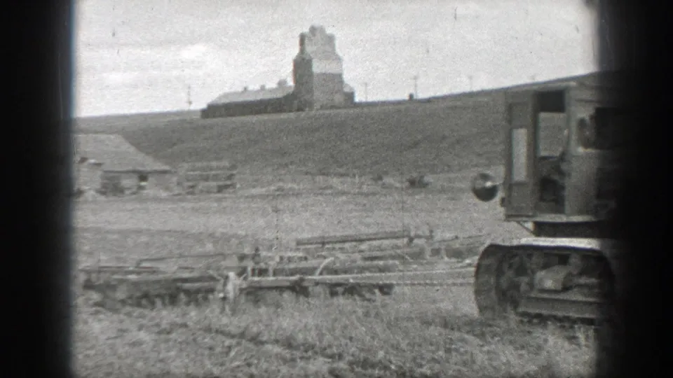 Tracked tractor appears near the edge of the 1937 California rural frame, with fencing, open ground, and a distant farm structure visible.
