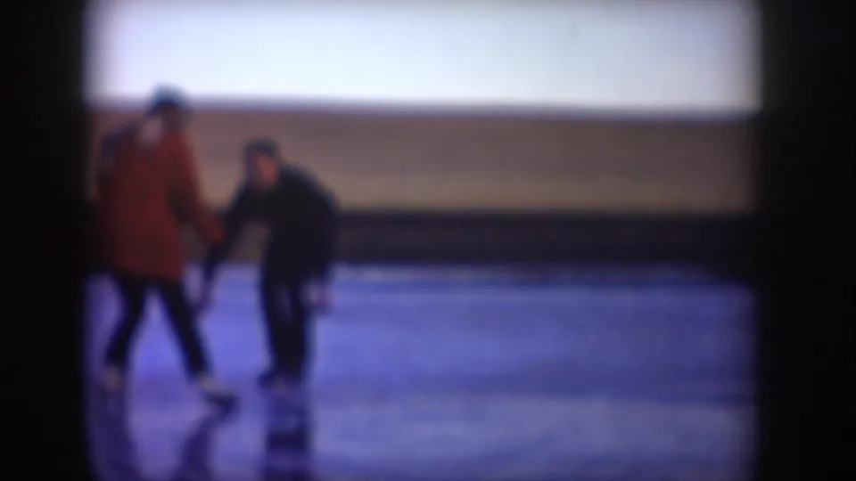 Closer 1953 home-movie view of two adults holding hands while skating on North Dakota ice.