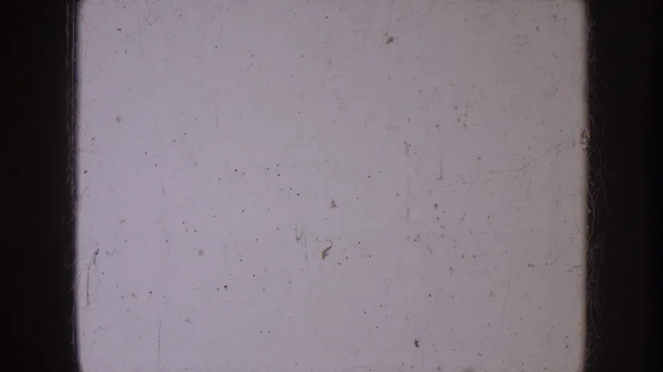 1953 North Dakota 8mm home-movie frame showing a light blank film area with dark borders, dust, scratches, and mild color unevenness.