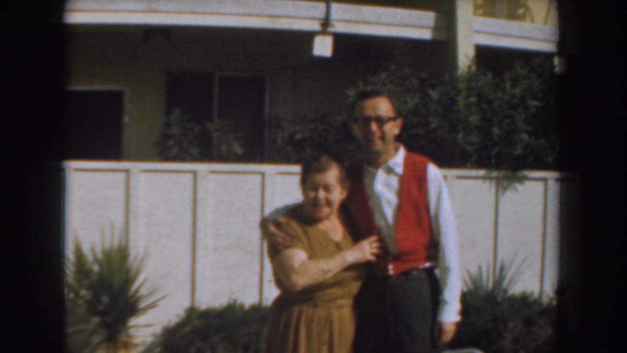 Man and woman standing together outside a residential building.