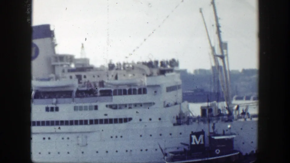 1948 New York harbor footage showing a large white ocean liner at port, passengers on upper decks, and a small tugboat alongside.