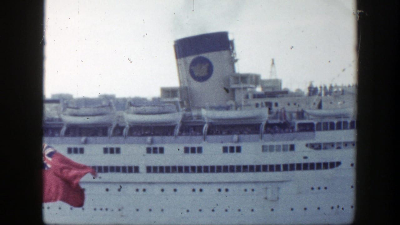 White ocean liner at dock with lifeboats, twin funnels, passengers, and a red flag in the foreground.