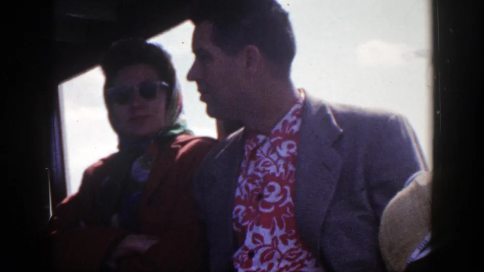 The woman sits near the bus window while the suited man faces her, both partly backlit in the 1948 New York clip.