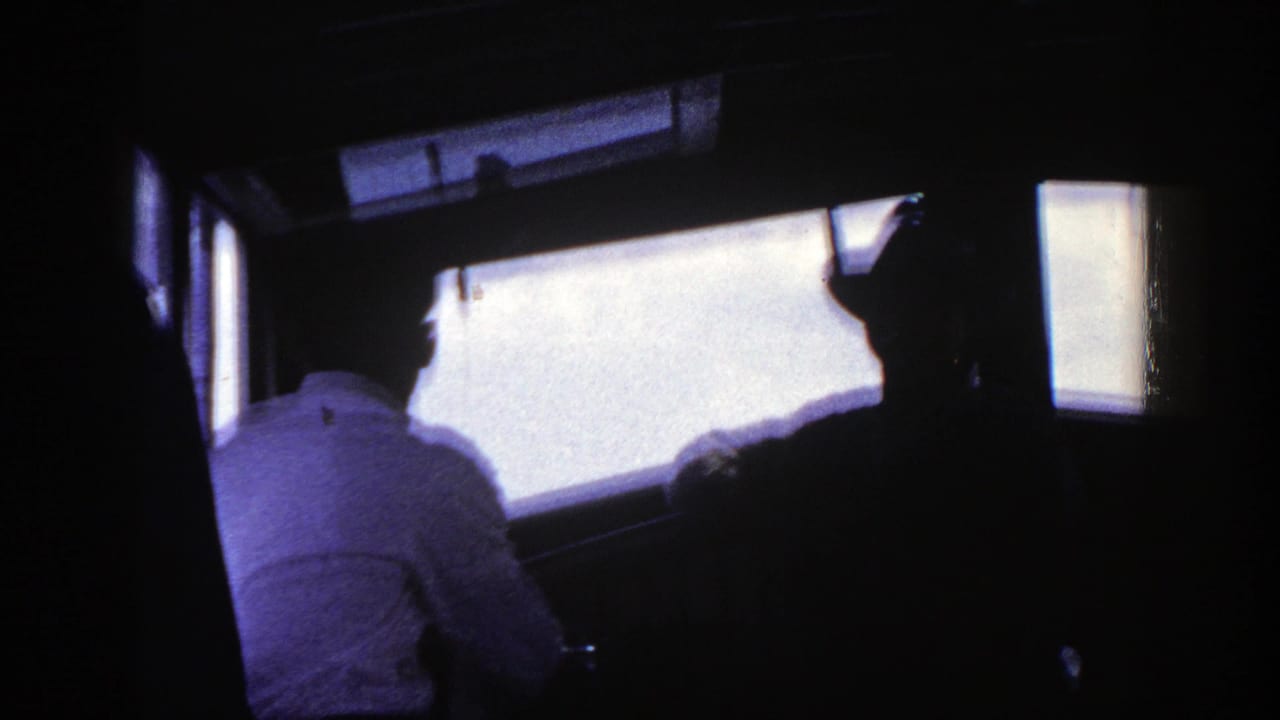 Dim vehicle interior with passengers silhouetted beside bright windows.