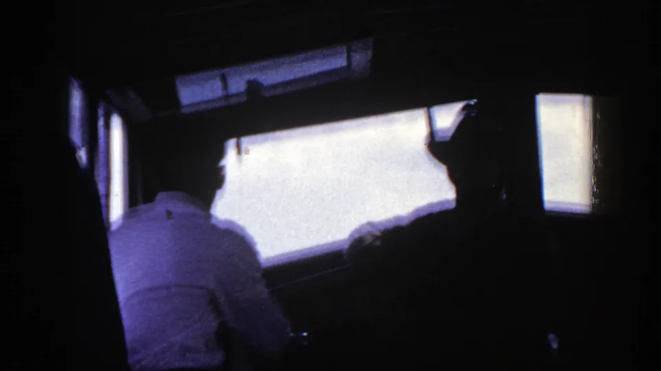 1948 New York 8mm frame showing a dim passenger interior with seated riders silhouetted against bright windows.