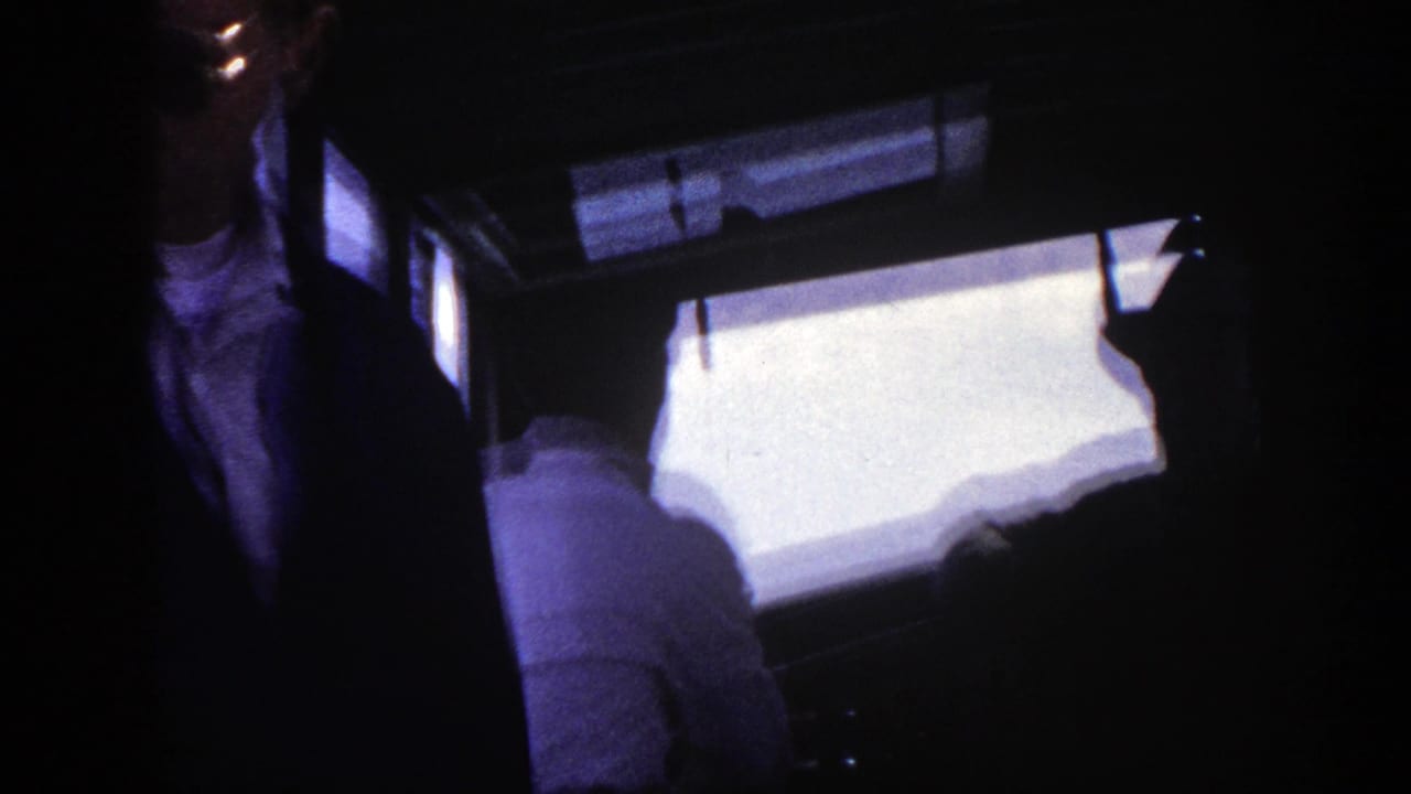 Dark passenger area with a man partly visible near bright windows.