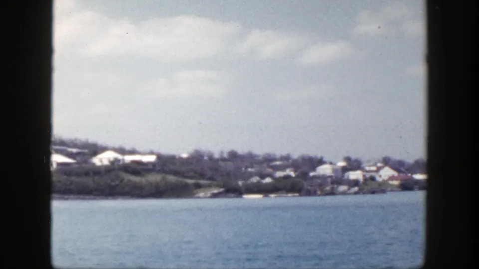 Distant New York shoreline in 1948 home-movie footage, framed by dark borders with water in front.