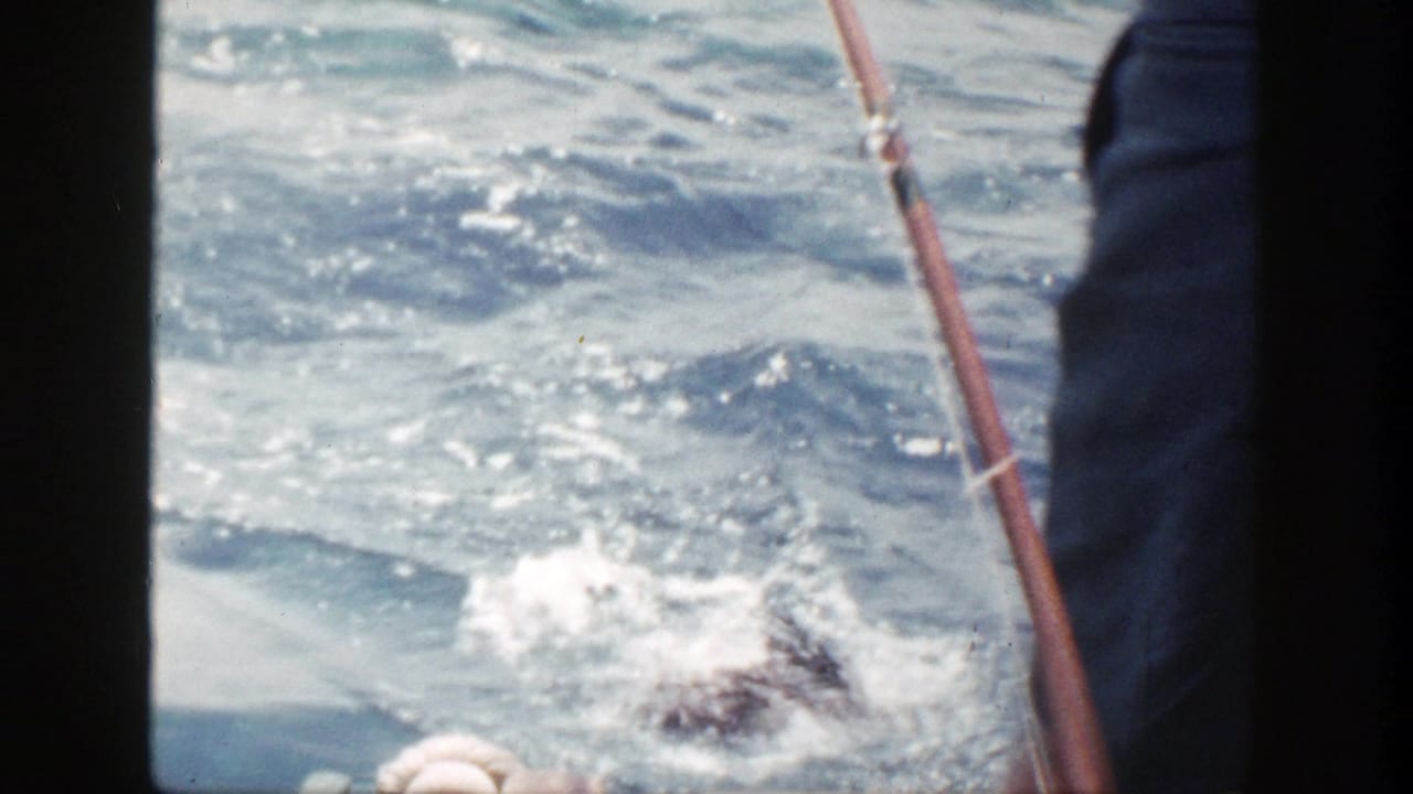 1948 New York 8mm frame showing a fishing rod over choppy blue water beside the edge of a small boat.