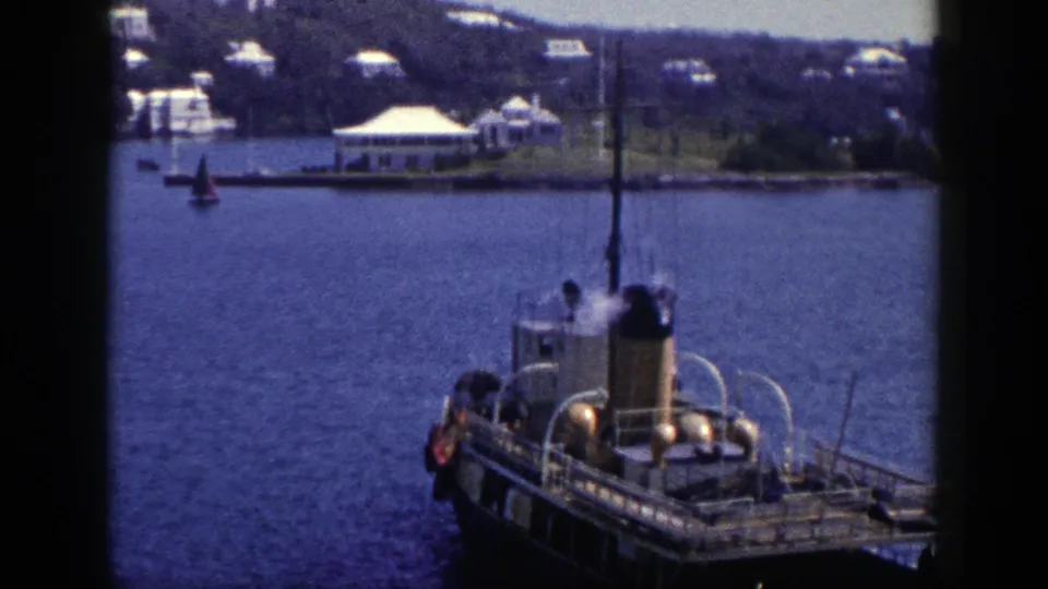 Soft 8mm 1948 New York harbor frame with the steam boat partly low in view and shoreline houses across the water.