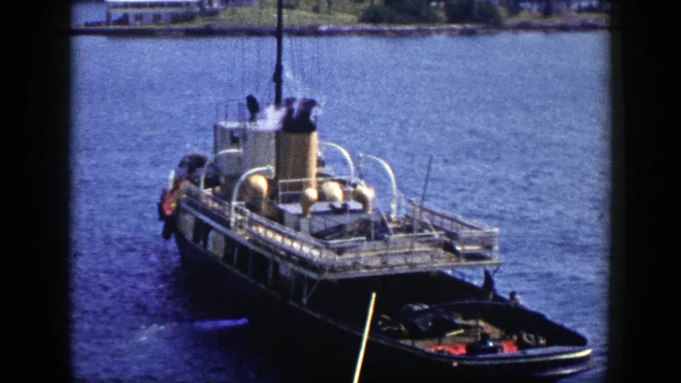 The 1948 New York harbor shot shows the steamboat closer in frame, with steam above the stack and another small vessel edge visible below.