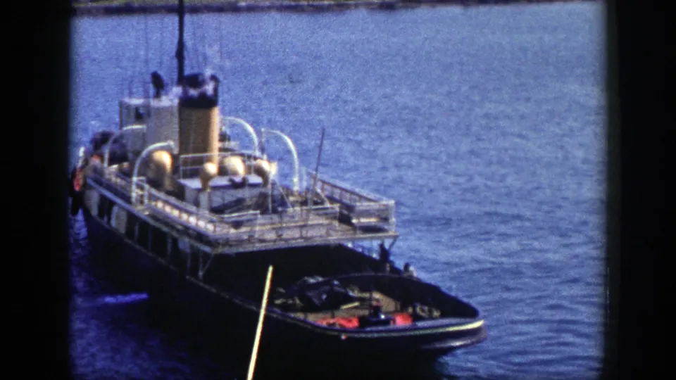 Final 1948 New York frame showing the tugboat from above, with its smoking stack, rail-lined deck, and small boat at the bow.