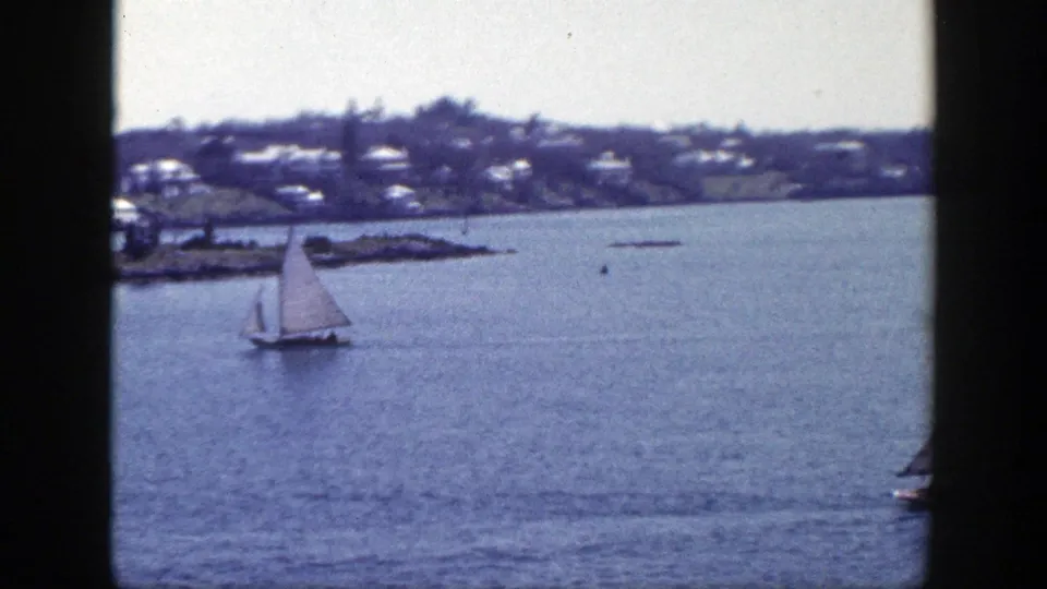 A small sailboat moves across open water in the 1948 New York waterfront home movie.
