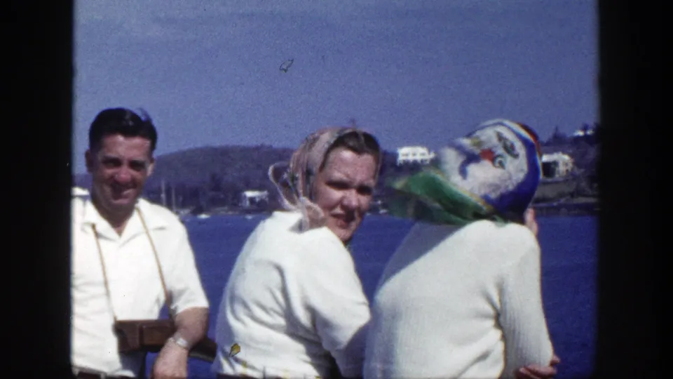 Three adults on a New York waterfront smile and look around in a brief 1948 8mm home-movie moment.