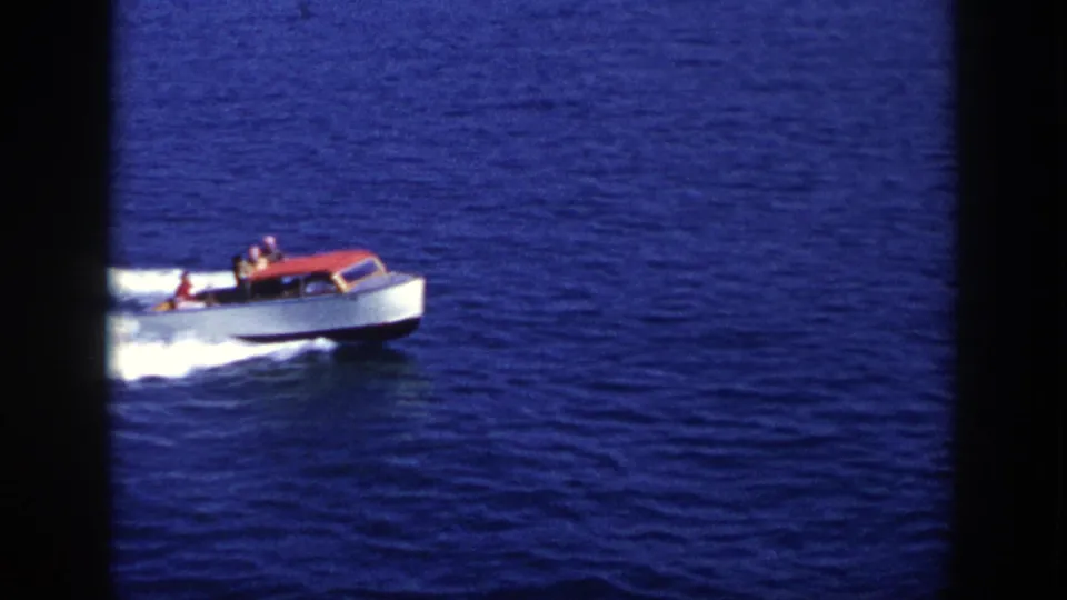 1948 New York home-movie frame of a small motorboat on open lake water, viewed from a distance.