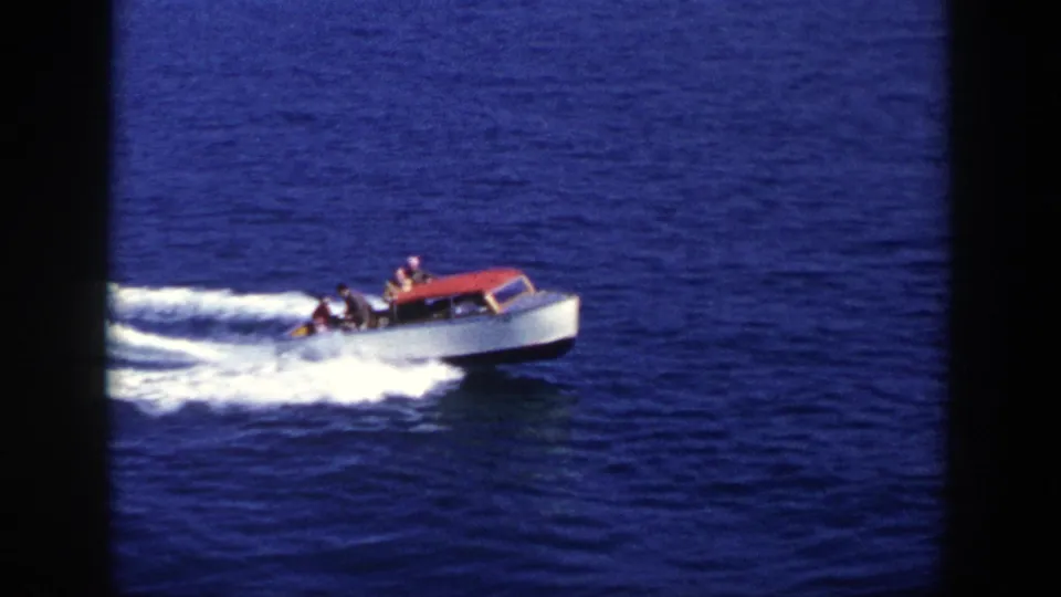 1948 New York footage frame with a small group riding in a red and white motorboat over open water.