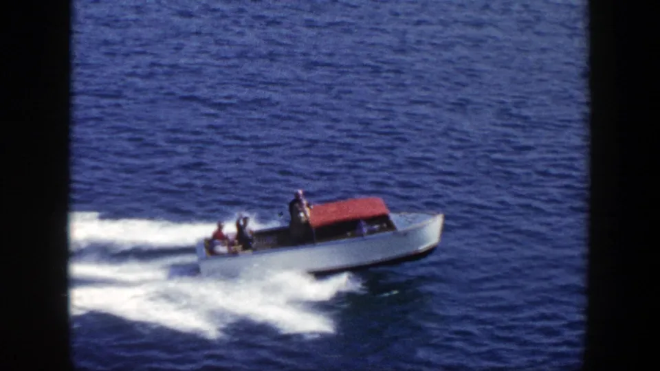 Final frame of the 1948 New York clip shows the red-canopied white motorboat continuing across open blue water.