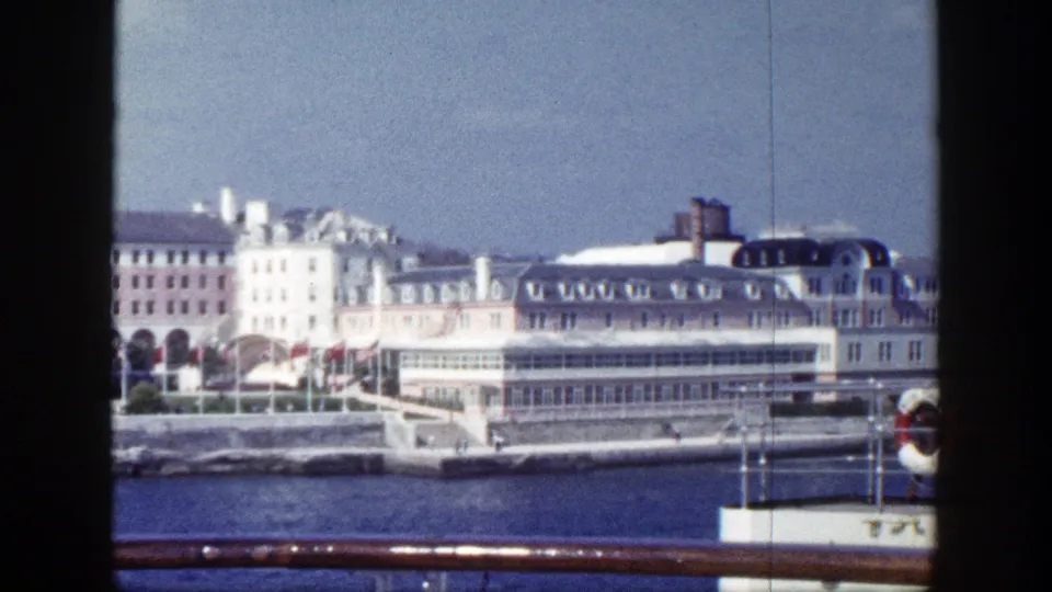 1948 New York frame showing a large shorefront building and glass-enclosed section from a vessel perspective.