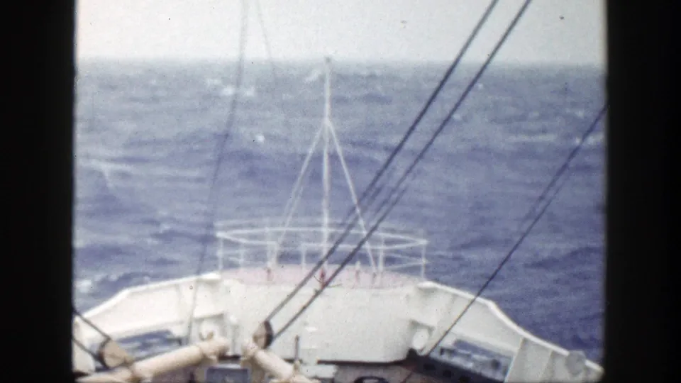 Forward 1948 home-movie view of a white ship bow with railings, antennas, and rigging cutting through choppy seas.