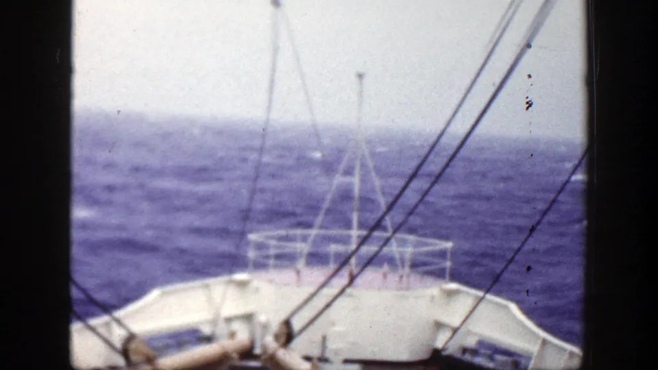 1948 8mm deck perspective with bow railings, rigging, and choppy open water filling the horizon.