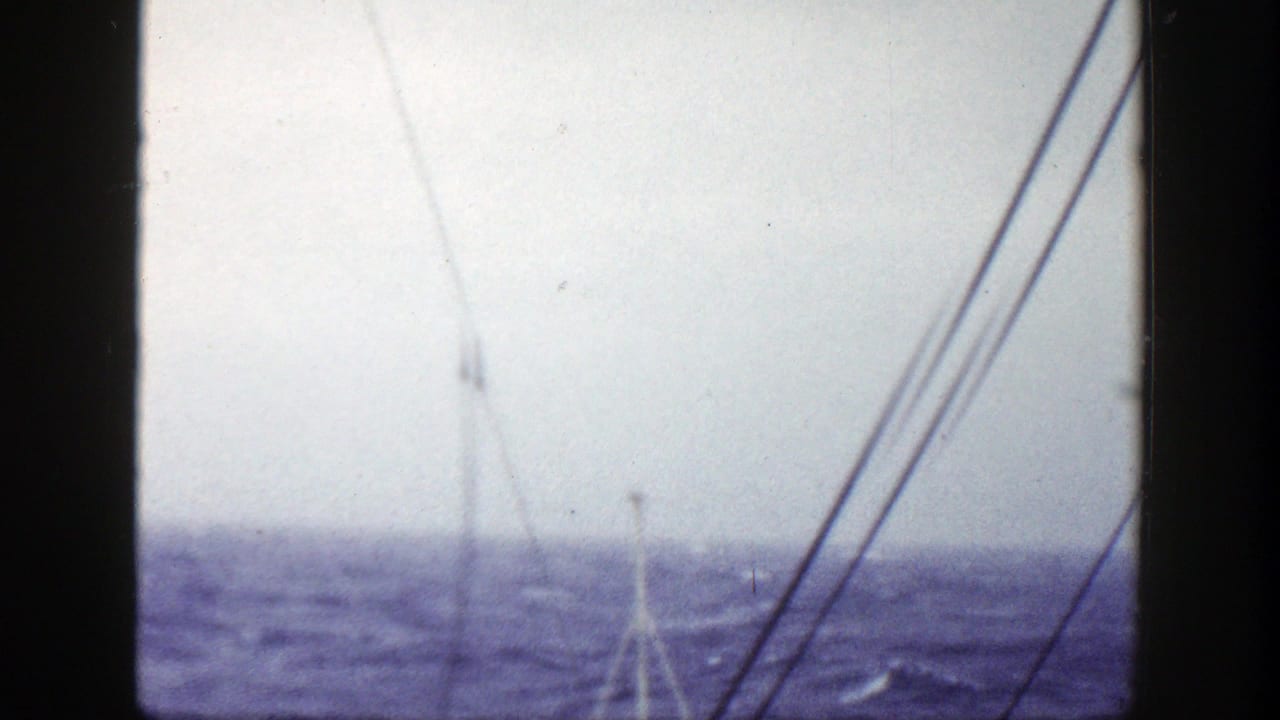 1948 8mm home-movie frame showing rigging and a ship deck facing a choppy sea, with no people visible.